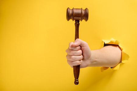 Hand holding a judges gavelの写真素材
