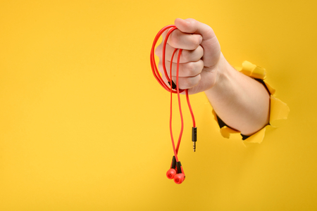 Hand holding red headphonesの写真素材