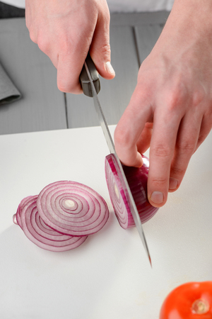 Man slicing a red onionの写真素材