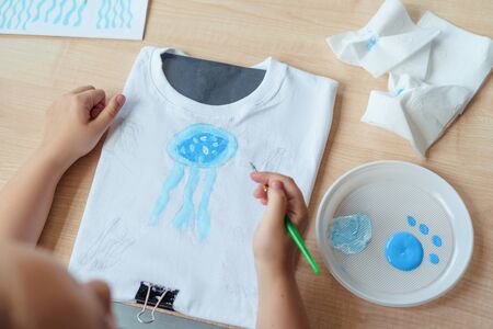 Child painting a blue jellyfishの写真素材