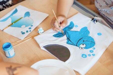 Child painting a blue fishの写真素材