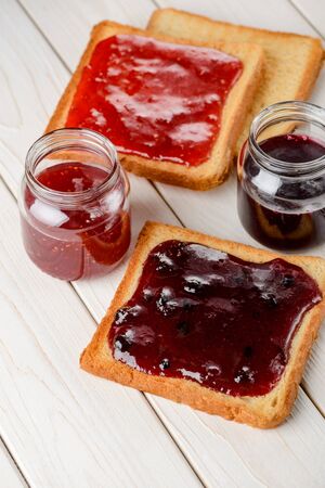 Spreading jam on toasted breadの写真素材
