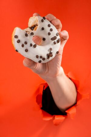 Hand holding a white doughnutの写真素材