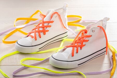 White sneakers with lattice lacing. Orange, yellow and violet shoelace to make your shoes look stylish.の写真素材