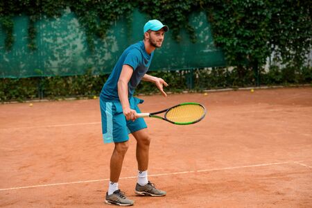 Man playing tennis at outdoor court.