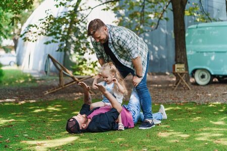 Gay family playing in backyard. Cheerful dads and their little daughterの写真素材