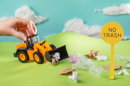 Kid playing with a toy truck that collects trash from lawnの写真素材