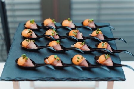 Mousse wrapped with bacon, decorated with watercress and placed on spoons