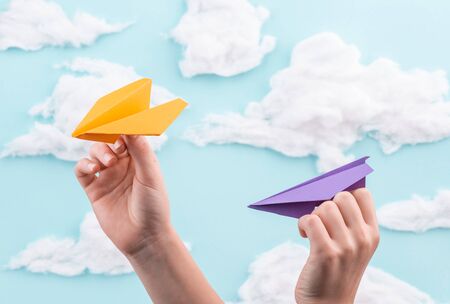 Kids playing with orange and violet paper planes
