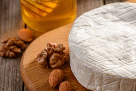 Brie cheese served with almonds, walnuts and honeyの写真素材