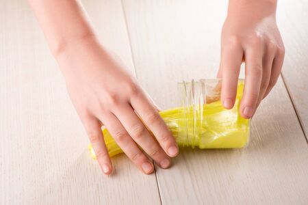 Kid getting a yellow slime out of a jarの写真素材
