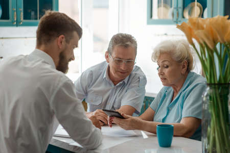 Elderly parents and their son decide to buy some propertyの写真素材