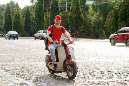 Handsome guy is driving a motorbike, delivery serviceの写真素材