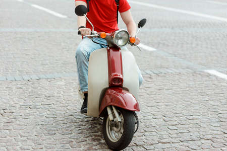 Beautiful retro style scooter. Man having a ride in the cityの写真素材
