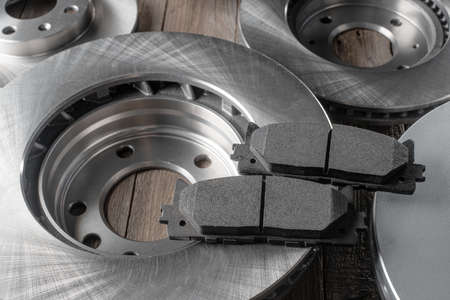 Brand new brake rotors and friction pads on wooden backgroundの写真素材