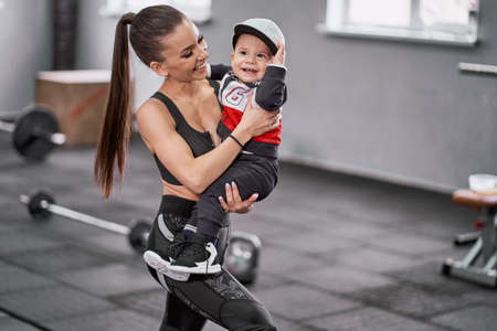 Sporty woman with her little child in the gymの写真素材