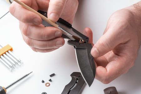 Technician removes dust from the joint of a knife