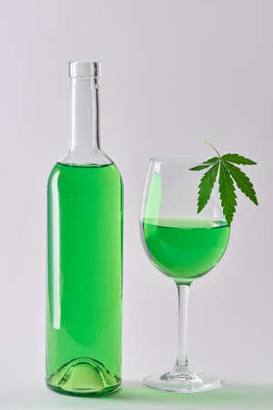 A bottle and a glass of weed wine on white backgroundの写真素材
