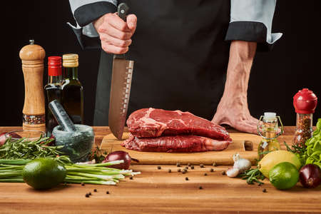 Chef cooking a beef steak. holding a sharp Santoku knifeの写真素材