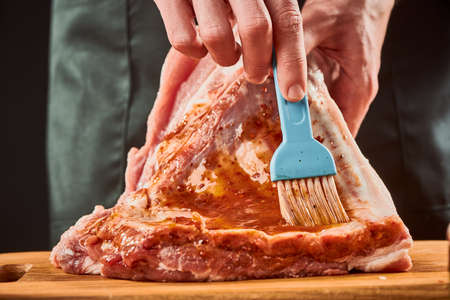Chef brushing beef ribs with sauce to marinate themの写真素材