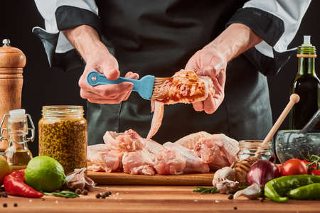 Chef brushing chicken wings with marinade sauceの写真素材