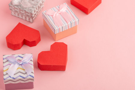 Small gift boxes and red paper boxes on pink background