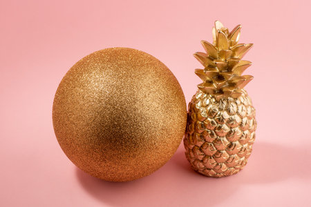 Golden pineapple and glitter ball on pink backgroundの写真素材