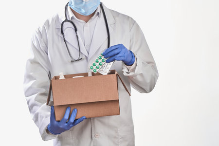 Doctor collecting ordered pills into a cardboard boxの写真素材