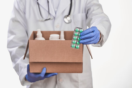 Doctor putting a set of prescribed pills into a boxの写真素材