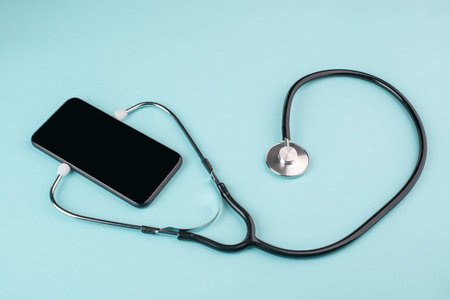 Phone with listening stethoscope on blue background