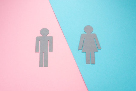 Paper dolls of man and woman on pink and blue backgroundの写真素材