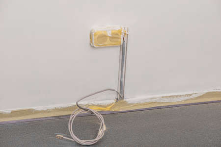 Power socket covered with masking tape while the wall being paintedの写真素材