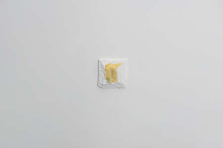 Power socket covered with masking tape while the white wall being paintedの写真素材