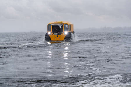 Yellow off-road vehicle sailing in the riverの写真素材