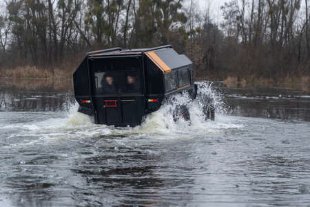 Amphibious off-road vehicle coming out of the riverの写真素材