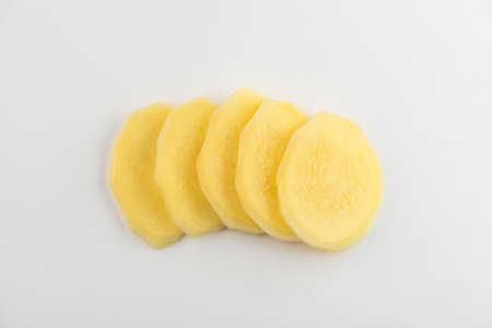 Top view on a pile of slices of a ginger root on white backgroundの写真素材