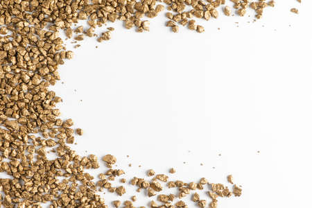 Top view on golden nuggets scattered on white backgroundの写真素材