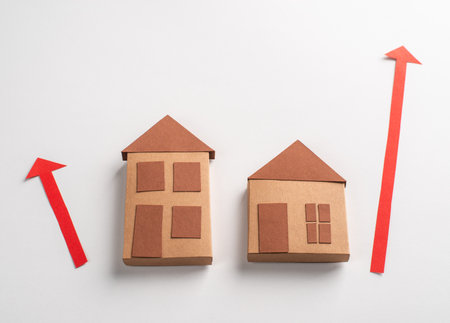 3d paper houses and red arrows pointing up on white backgroundの写真素材