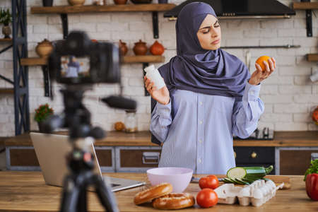 Arabian female food blogger comparing supplements and natural foodの写真素材