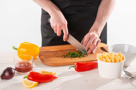 Man cutting green pepper and other vegetables for sauce andalouseの写真素材