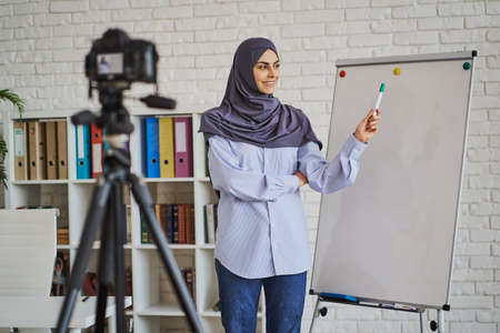Young Arabian woman making a video with a business lectureの写真素材