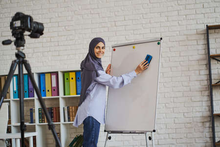 Arabian teacher recording a video with her lectureの写真素材