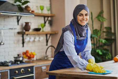 Arabian woman cleaning a table in the kitchenの写真素材