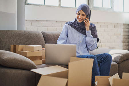 Muslim business woman having a call and looking at a laptopの写真素材