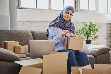 Portrait of a Muslim business woman packaging orders into cardboard boxesの写真素材