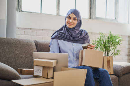 Beautiful Muslim business woman working from home and getting orders readyの写真素材