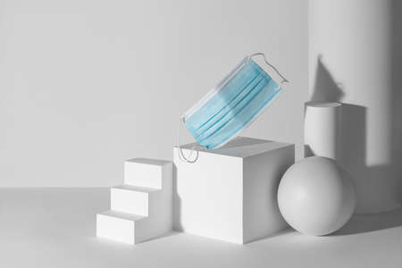 Blue face mask among 3d paper shapes with copy spaceの写真素材