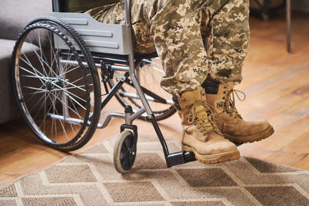 Close-up on legs of a military man sitting in a wheelchairの写真素材