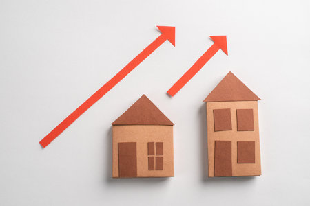 3d paper houses and red arrows pointing up on white backgroundの写真素材