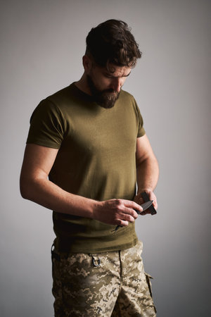 Strong military man sharpening his pocket knife with a whetstoneの写真素材